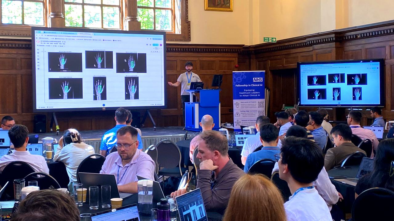 Cohort 5 fellows at the bootcamp working through a demonstration of an AI model on hand radiographs